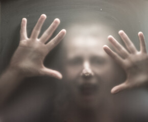 Scary picture of hands behind glass.
