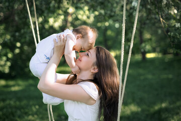 Happy childhood of a healthy child. Close-up baby in mother's arms.  Mom pressed against the...