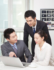 Group of businesspeople discussing working on computer