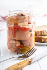 Pickled sausages with onion and red pepper. Marinated food.