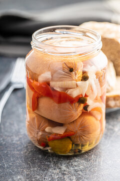 Pickled sausages with onion and red pepper. Marinated food.