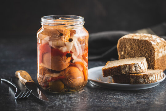 Pickled sausages with onion and red pepper. Marinated food.