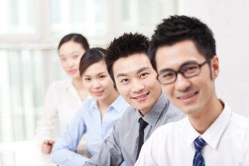 Fototapeta premium Executives sitting at conference table focus on woman in foreground 