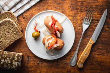 Pickled sausages with onion and red pepper. Marinated food.