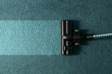 Cleaning service concept. Process of hoovering carpet with vacuum cleaner, closeup. Housekeeping...