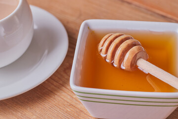 Honey and honey dipper in a dish.
