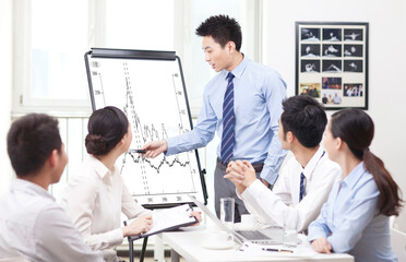 Fototapeta premium Businessman pointing at graph during presentation in boardroom