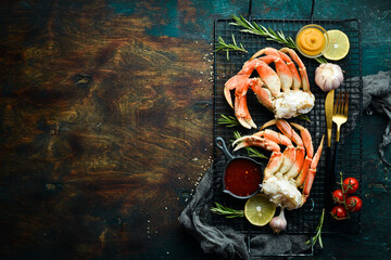 Boiled crab claws with sauce and lemon. Rustic style. Luxury Seafood Delicacies.