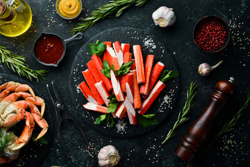 Crab sticks from a crab on a black stone plate. Rustic style. Seafood delicacies. © Yaruniv-Studio
