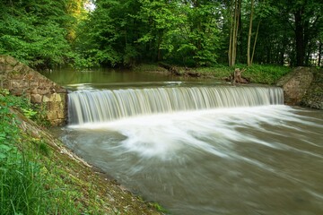 Weir on the river. Water whirlpools behind it. River Juhyne. East Moravia. Czech Republic. Europe.