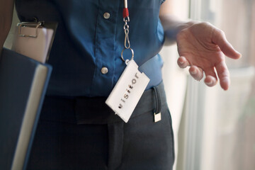 Businesswoman wearing Visitor lanyard standing at office