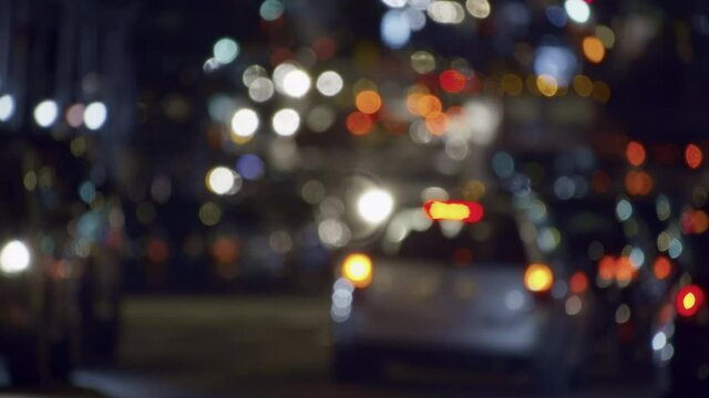 Abstract blurry New York City street traffic by night, slow driving cars, flickering lights