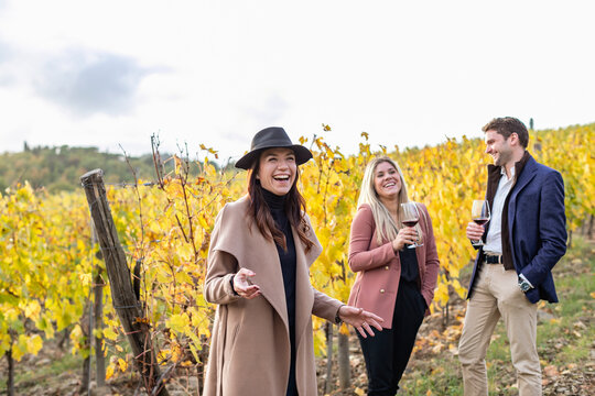 Smiling businesswoman showing vineyard to clients during autumn