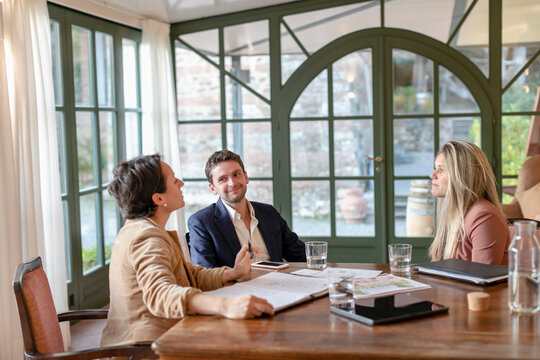 Young couple in meeting with female wedding planner in her studio
