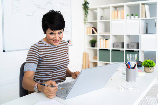 Portrait of businesswoman working at office in front of laptop