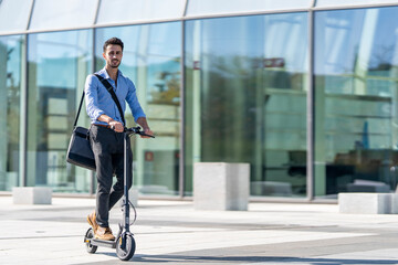 Businessman riding electric push scooter on footpath