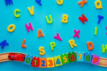 Educational toys blocks, numbers, letters, train on blue background. Toys for kindergarten, preschool or daycare. Early childhood education, learning to count, preschool and kids game concept