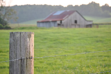 Fototapeta premium Fence post with a barn in the background