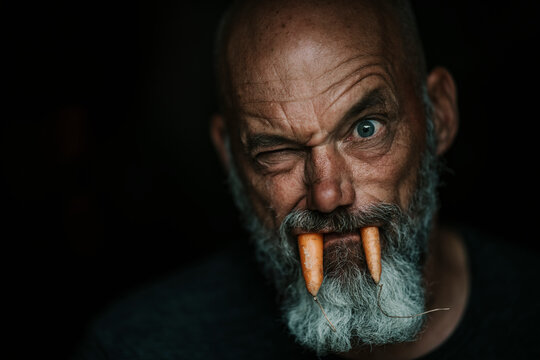 Close-up of farmer with carrots in mouth