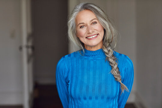 Happy mature woman with gray hair at home