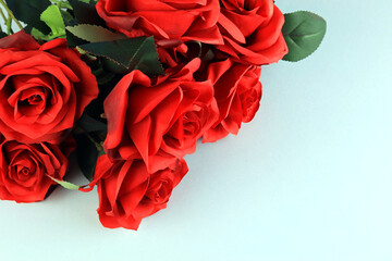 bouquet of artificial red roses on a plain background.