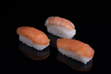 classic sushi with salmon isolated on black with reflection