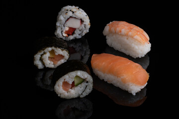 Sushi rolls and classic suchi with salmon isolated on black close up