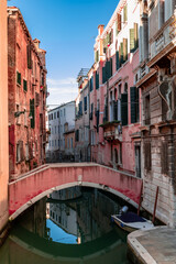 Fototapeta na wymiar Canal in venice with a reflection of a bridge
