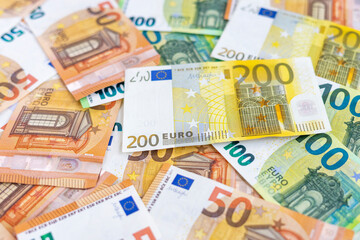 Euro bills of different value. Several euro banknotes for the background and texture. Selective focus on 200 euro banknotes