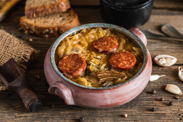 Christmas cabbage soup in ceramic bowl on natural wooden background.
