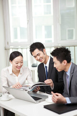 Group of businesspeople discussing with a magazine in office