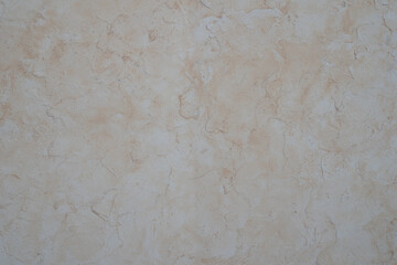 Decorative beige plaster texture on the wall, background.