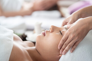 Obraz na płótnie Canvas Side View of Asian Woman Receiving Head Massage in a Spa
