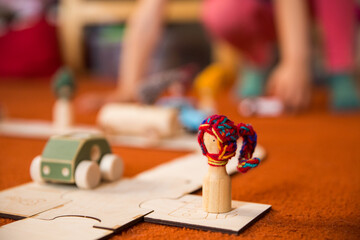 Hands of a child playing with wooden toys at home. Colorful interior of a children's room.