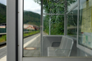 Vandalismus an Wartehäuschen auf einem kleinem Bahnhof mit kaputter Scheibe - Stockfoto