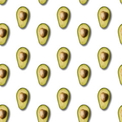 Seamless pattern of avocados halved low on light  background.
