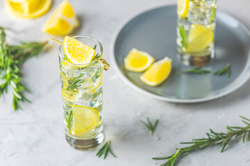Two glasses of refreshing lemon lime drink with ice cubes in glass goblets against a light gray...