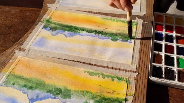 watercolorist at work, making of a colorful artwork