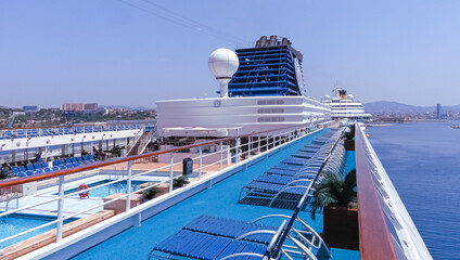 Obraz premium Vue du pont supérieur et des transats d'un navire de croisière en escale au terminal du port de Marseille. 