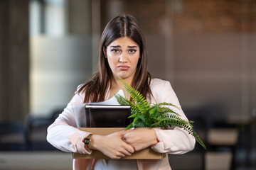 Sad woman leaving the office and carrying her belongings after getting fired from work due to COVID-19 pandemic. Unemployed businesswoman lost her business. Anxious concept