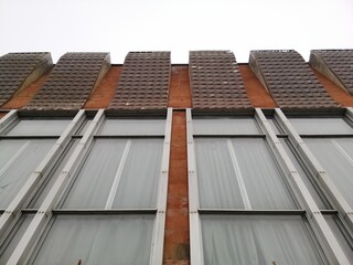 Urban Geometry, underside view to red steel old building. A fragment of the exterior of the building in the style of modernism.
