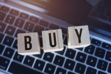 Wooden cubes with word buy on laptop keyboard. Online Shopping concept.
