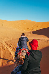 Zwei Frauen auf einem Kamelritt durch die Wüste von Marokko. Ausflug durch die Sahara in Afrika.
