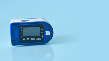 Portable Pulse oximeter isolated on blue background.Copy space for text.