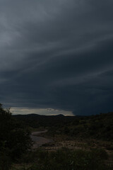Strong lightning in and behind big towering thunderclouds