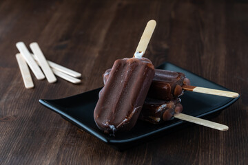 Close up of a dish with chocolate covered ice cream bars ready for sharing.