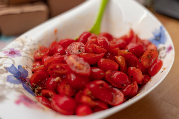 close up of hand holding a white bowl of fresh cherry tomatoes, homemade tomato salad, fresh fruits