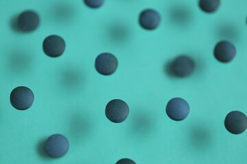  Spirulina algae tablets.Dietary supplements. Spirulina pills  on a turquoise background.Super food. Healthy organic seaweed.Healthy lifestyle. Food product.Dry algae tablets