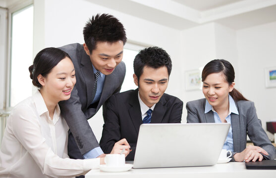Group of businesspeople discussing working on computer