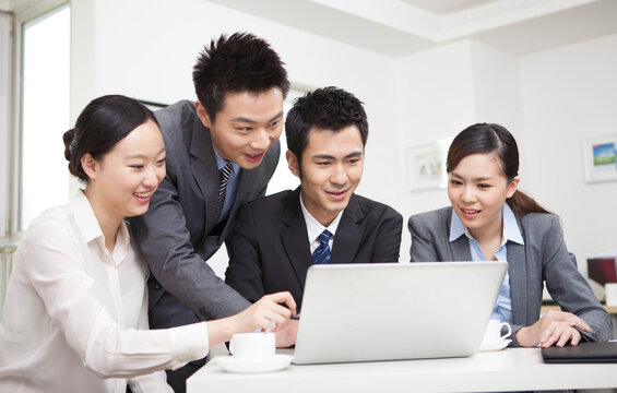 Group of businesspeople discussing working on computer